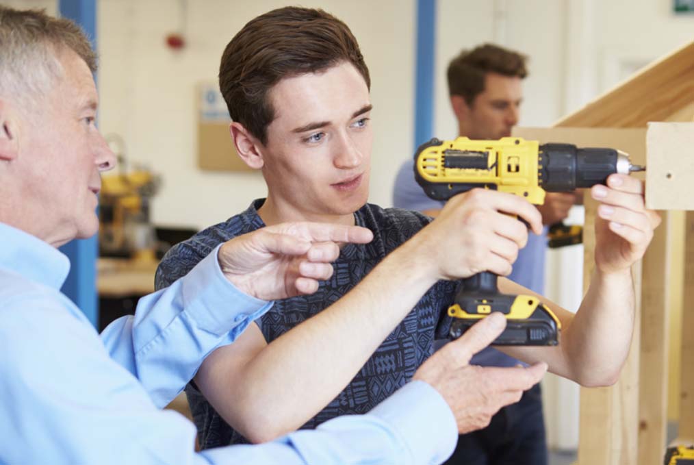 A tutor guiding a student through practical trade training